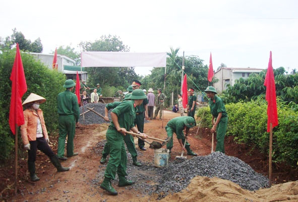 Cán bộ, chiến sĩ Trung đoàn 584 giúp nhân dân xã Hòa Xuân  làm đường bê tông liên thôn.