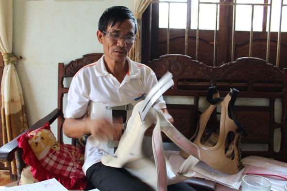 Ông Nguyễn Quang Duẩn bên các thiết bị y tế hỗ trợ mình.