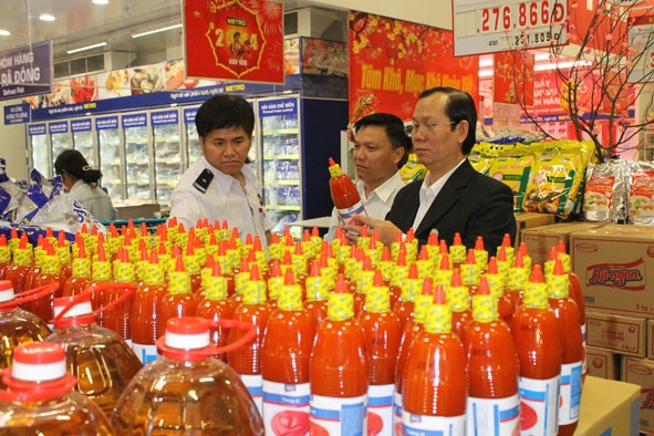 Bác sĩ Trần Văn Tiết (bìa phải) tham gia kiểm tra chất lượng thực phẩm  tại một cơ sở kinh doanh trên địa bàn TP. Buôn Ma Thuột.  
