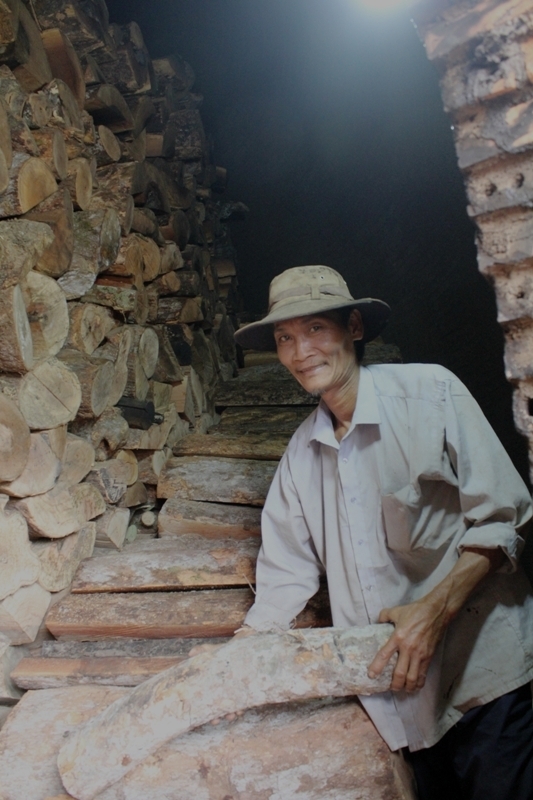 Một người dân đang chất gỗ rừng vào lò than 