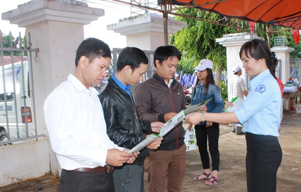 Nhân viên Trung tâm Truyền thông Giáo dục sức khỏe tỉnh phát tờ rơi tuyên truyền phòng chống tác hại thuốc lá cho người dân huyện Cư Kuin. 