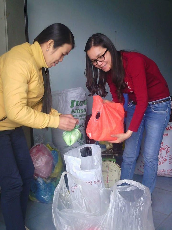 Cô giáo Lê (bên phải) tập kết số gạo được quyên góp từ phong trào hũ gạo tiết kiệm.  Ảnh:  N. Trang