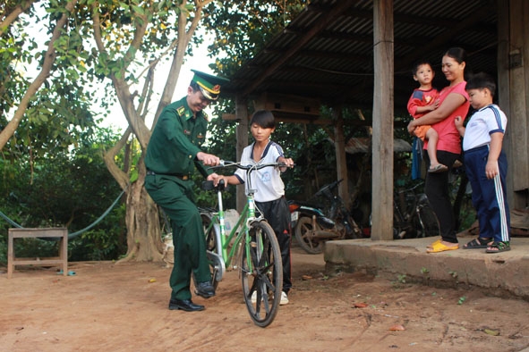 Thượng tá Nguyễn Hữu Phúc trao xe đạp tặng học sinh nghèo.  