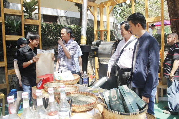 Khách nước ngoài tham quan, tìm hiểu về cà phê nguyên chất tại gian hàng của Công ty Cà phê Kinh Bắc (Buôn Ma Thuột).