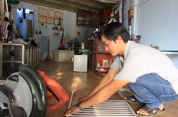 Anh Nguyễn Trương Tuấn đang làm các sản phẩm nhôm kính cho khách hàng.   