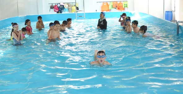 Các em học sinh Trường THCS Đinh Tiên Hoàng được hướng dẫn học bơi.   