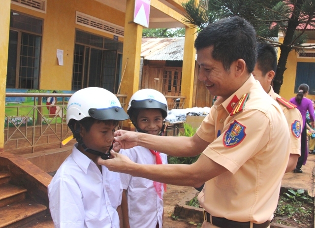Cảnh sát giao thông Công an huyện Cư M'gar trao mũ bảo hiểm tặng học sinh Trường Tiểu học Lê Thị Hồng Gấm (huyện Cư M'gar).