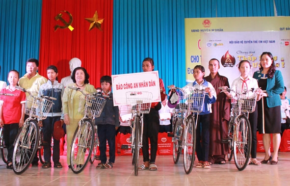 Đại diện các đơn vị trao xe đạp tặng học sinh nghèo vượt khó huyện M’Đrắk. 