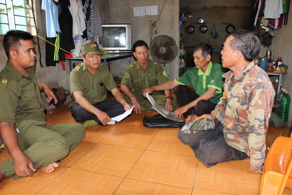 Lực lượng Công an xã Dray Bhăng trao đổi thông tin ANTT trên địa bàn xã với các tổ  tự quản ANTT. 