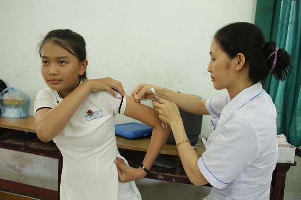 Nhân viên Trạm Y tế thị trấn Liên Sơn tiêm vắc xin viêm não Nhật Bản B cho học sinh Trường THPT huyện Lắk.