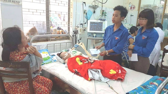 Chị Trần Thị Vui, Bí thư Đoàn xã Dray Bhăng thăm hỏi bệnh nhi có hoàn cảnh khó khăn. 