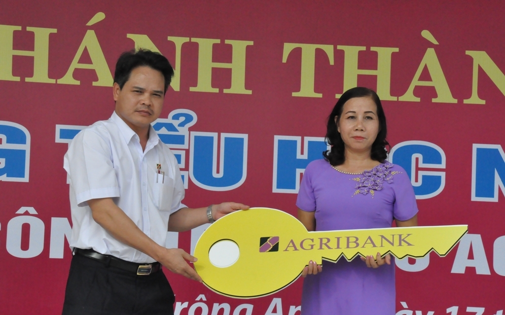 Giám đốc Agribank Đắk Lắk Vương Hồng Lĩnh trao chìa khóa tượng trưng cho lãnh đạo Trường Tiểu học Nguyễn Viết Xuân