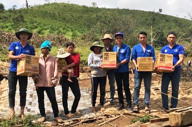 Các bạn thanh niên tình nguyện trao quà cho người dân bị thiệt hại nặng do bão số 12 gây ra ở xã Yang Mao.