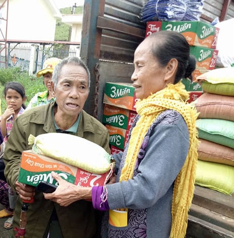 Bà Trần Thị Lịch (xã Cư Đrăm) tặng gạo, mì tôm và quần áo cho bà con bị thiên tai ở xã Yang Mao. 
