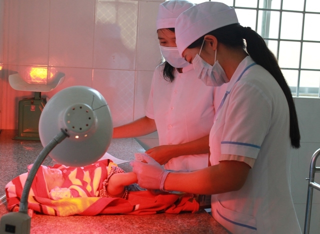 Lấy máu gót chân của trẻ để sàng lọc sơ sinh tại Bệnh viện Đa khoa huyện Ea Kar. 