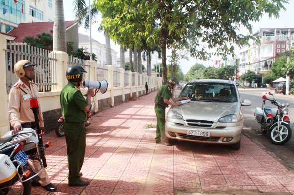 Lực lượng chức năng thông báo tìm phương tiện đỗ xe sai quy định trên vỉa hè tại phường Tân An.