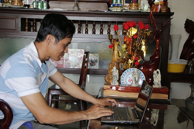 Anh Trần  Mạnh Linh  (trú tổ  dân phố 4, phường  Thành Nhất,  TP. Buôn  Ma Thuột)  truy cập Internet  để tìm đầu ra ổn định  cho nông sản của mình.  