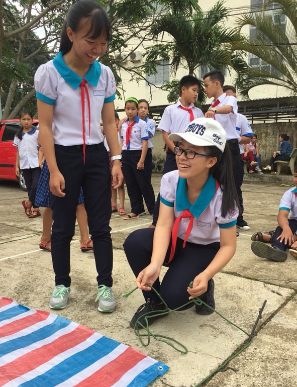 Em Nguyễn Ngọc Thị Thanh Huyền (phải)  đang hướng dẫn các bạn trong liên đội cách  dựng lều chữ A.  