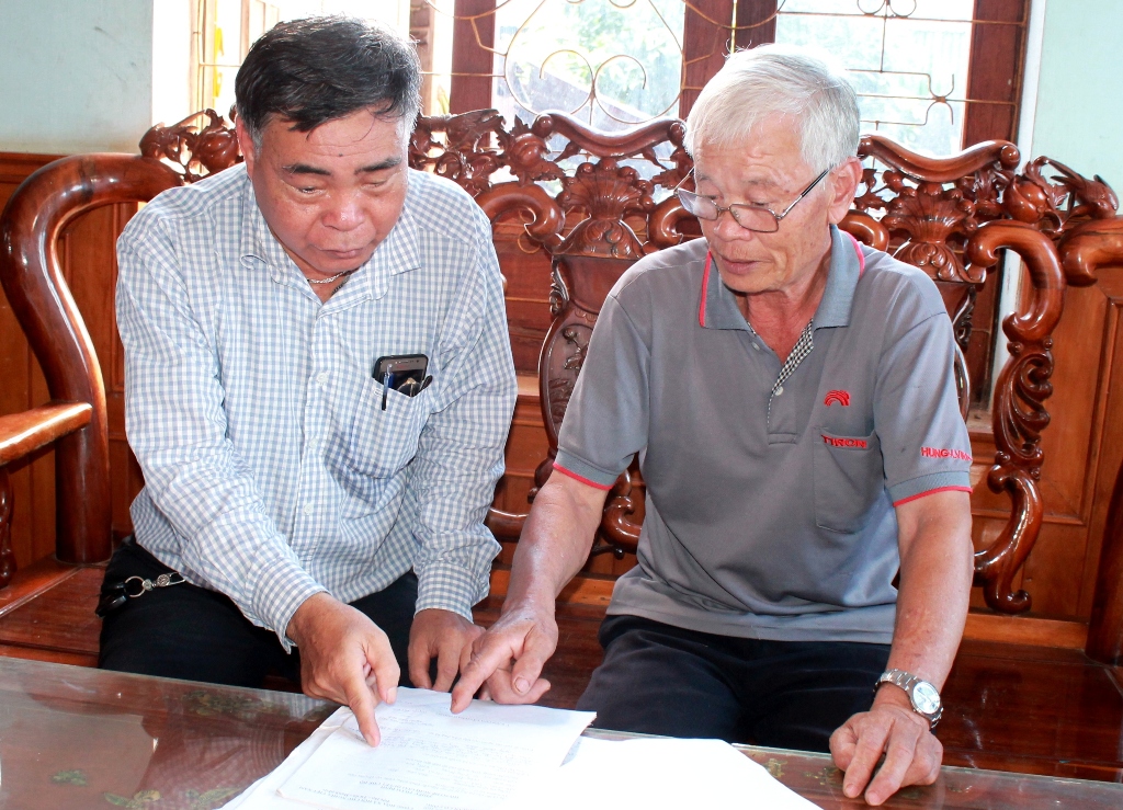 Ông Trịnh Xuân Vạn  (bìa phải) ở xã  Pơng Drang, huyện  Krông Búk kể về  quá trình làm hồ sơ giải quyết chế độ  cho người tham gia  hoạt động kháng chiến  bị nhiễm  chất độc  hóa học. 