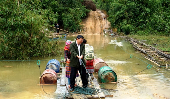 Người dân thôn Ea Rớt (xã Cư Pui, huyện Krông Bông) bất chấp nguy hiểm đi bè qua vùng nước ngập.    