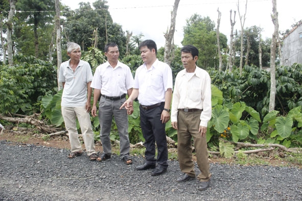 Ông Võ Sỹ Tùng (Chủ tịch UDND xã Ea Mnang, thứ 2 từ phải sang) đang trao đổi, vận động bà con làm đường giao thông nông thôn. 