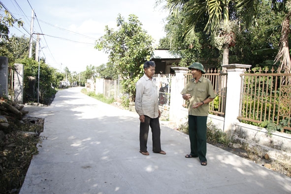 Ông Nguyễn Bá Chuyên, Trưởng thôn 1B, xã Cư Ni (bên phải) trên con đường mới được bê tông hóa khang trang.  