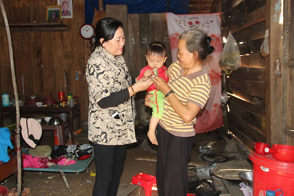 Bà Mai Thị Hoa, Chủ tịch Hội LHPN xã Ea H'leo (trái) đến thăm hỏi gia đình chị Mông Thị Lanh. 