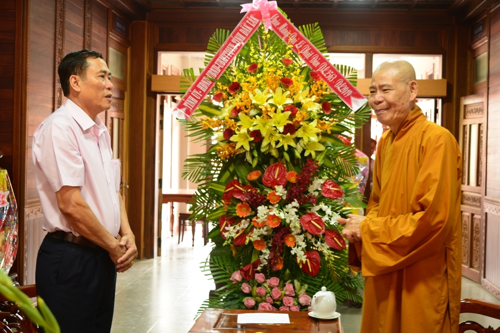 Phó Chủ tịch UBND tỉnh Võ Văn Cảnh (phải) tặng hoa, chúc mừng Trưởng ban trị sự giáo hội Phật giáo tỉnh, trụ trì chùa Khải Đoan 