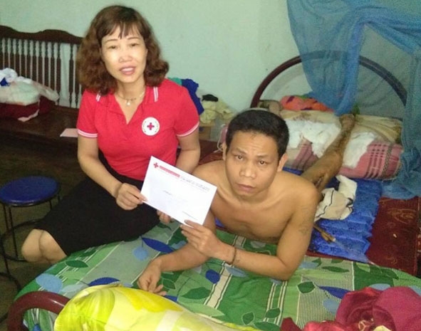 Phó Chủ tịch Hội Chữ thập đỏ TP. Buôn Ma Thuột Nguyễn Thị Lý trao tiền hỗ trợ cho nạn nhân bị tai nạn giao thông ở phường Ea Tam.