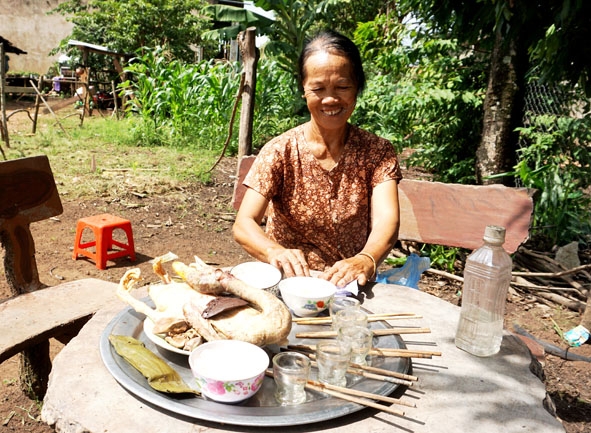 Bà Nông Thị Vườn ở thôn 6A, xã Ea Wy sửa soạn mâm cỗ cúng thổ công trong làng.