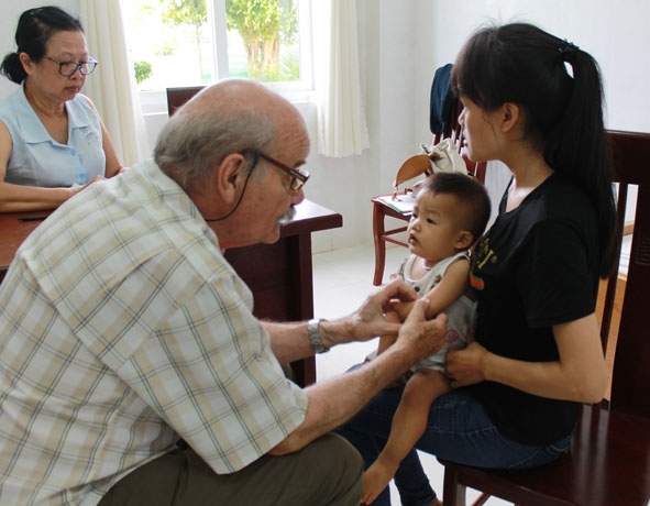 Bác sĩ của Tổ chức phi chính phủ Children Action thăm khám cho trẻ bị dị tật  cơ xương khớp.