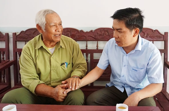 Ông K’Đin ở buôn Pưk Prông, xã Ea Ning, huyện Cư Kuin trao đổi công việc cùng cán bộ Công an huyện Cư Kuin. 