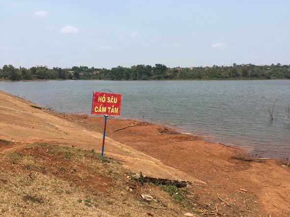 Một hồ nước ở xã Ea Tul được cắm biển cảnh báo. 