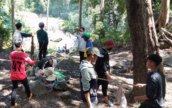 Đoàn viên thanh niên xã Cư Pui dọn vệ sinh khu vực thác Đắk Tuôr.  