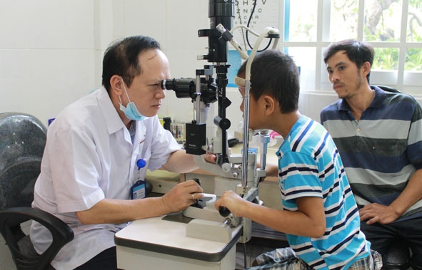 Cháu Nguyễn Trọng Hanh đang được bác sĩ khám phân loại bệnh. 