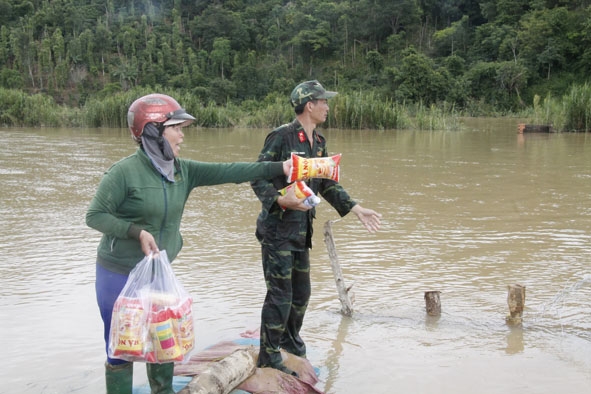 Chị Hoàng Thị Hoa tiếp tế bánh mì cho lực lượng vũ trang tham gia ngăn đê khu vực cánh đồng B, xã Quảng Điền.