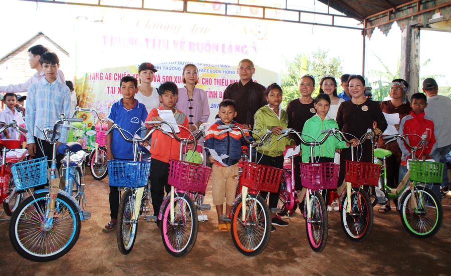 Các em nhỏ ở xã Cư né nhận xe đạp tại chương trình