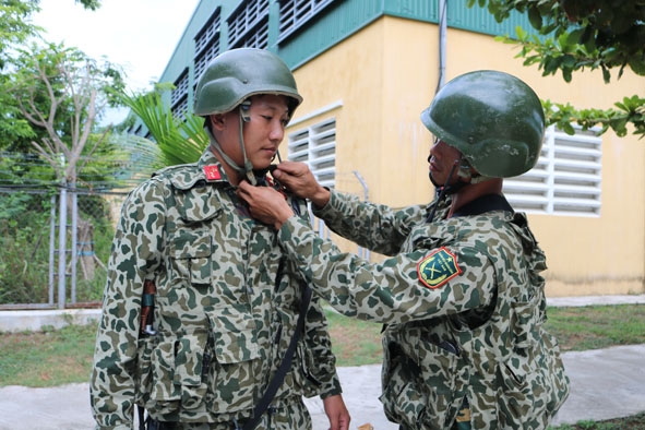 Đồng đội hỗ trợ Trung úy Lê Văn Huy mang đeo trang bị.