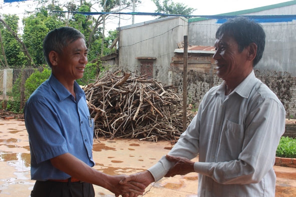 Ông Trần Công Hiên (bên phải) chia sẻ niềm vui với lãnh đạo UBND xã Ea Ktur khi con đường thôn 10 hoàn thành. 