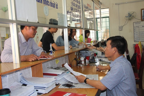 Cán bộ, công chức Bộ phận tiếp nhận và trả kết quả giải quyết thủ tục hành chính phường Ea Tam trả kết quả cho công dân.