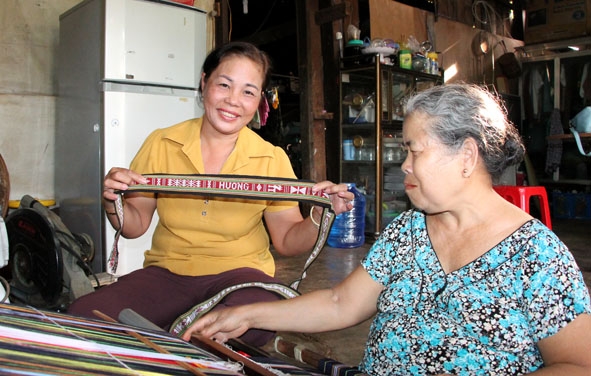 Chị Nguyễn Thị Thanh Hương (bài trái), Trưởng buôn Alê A, phường Ea Tam thăm mô hình dệt thổ cẩm của người dân trong buôn.
