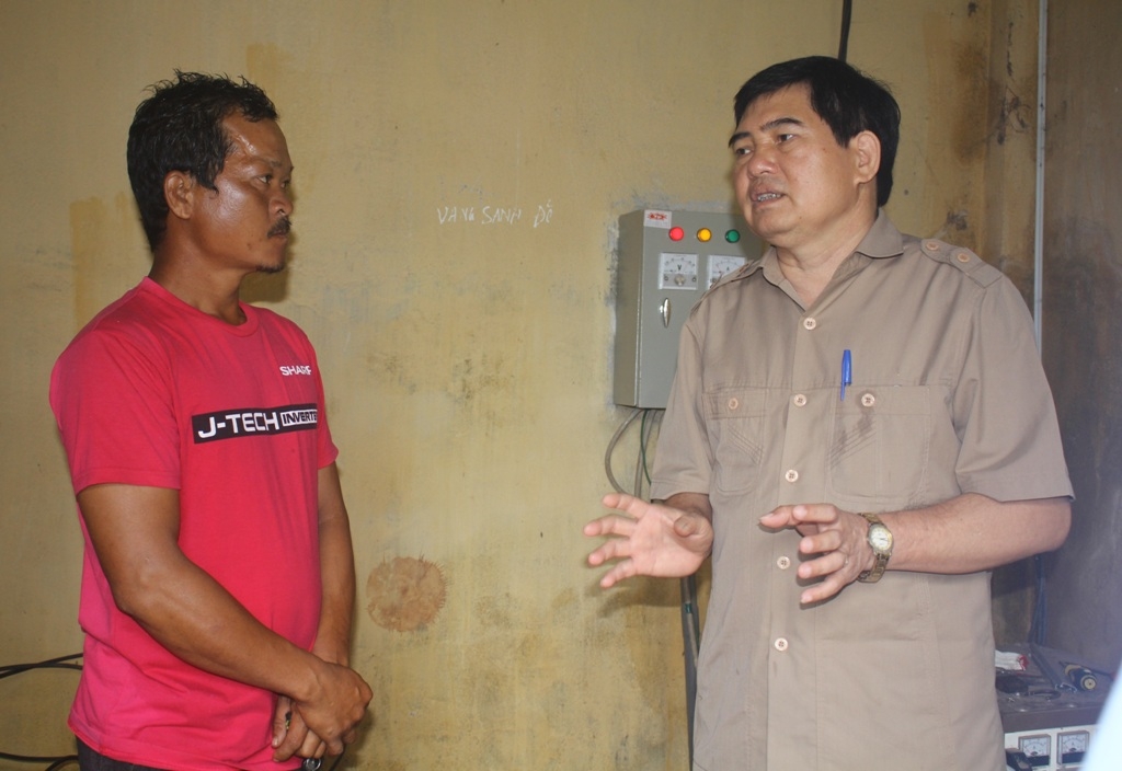 Phó Trưởng Đoàn chuyên trách Đoàn đại biểu Quốc hội tỉnh Y Khút Niê (bên phải) trao đổi với nhân viên quản lý công trình nước sinh hoạt tập trung buôn Jang Pông.