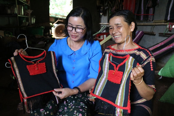 Bà H’Bin Niê (bên phải) với sản phẩm thổ cẩm do Tổ hợp tác dệt thổ cẩm – rượu cần làm ra. 