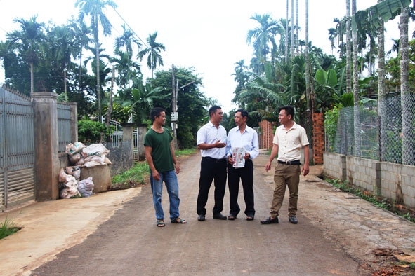Phó Chủ tịch UBND xã Ea Tiêu Y Khôn Knul (thứ 2 từ trái sang) trao đổi việc hiến đất làm đường với người dân thôn 4, xã Ea Tiêu.