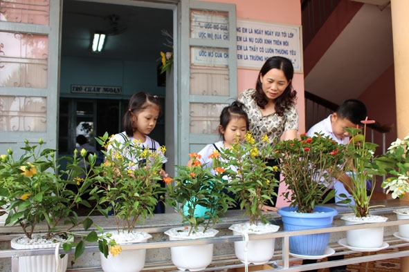 Giáo viên Trường Tiểu học Nguyễn Công Trứ (TP. Buôn Ma Thuột) cùng học sinh chăm sóc cây xanh trong khuôn viên nhà trường. 