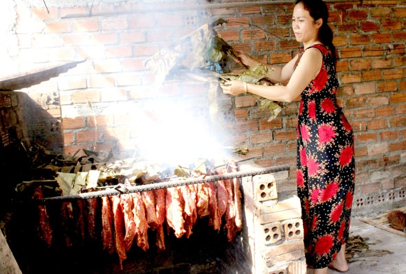 Chị Lù Thị Hạnh đang làm thịt gác bếp. 