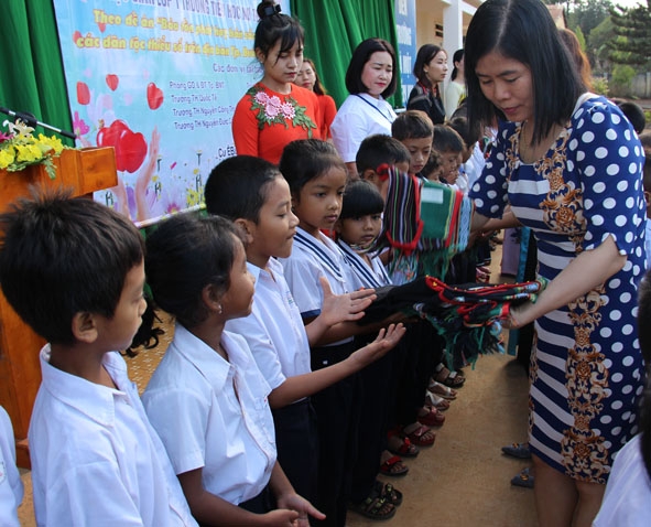 Đại diện Phòng GD-ĐT TP. Buôn Ma Thuột tặng trang phục truyền thống cho học sinh  Trường Tiểu học Nơ Trang Lơng.   
