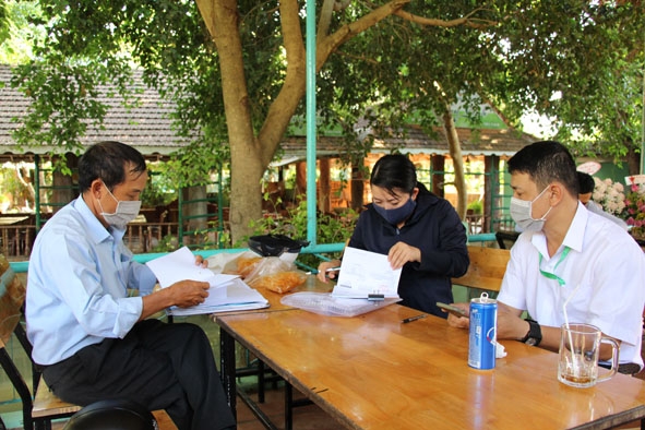 Cán bộ ủy nhiệm thu phát thông báo và thu thuế khoán cho một hộ kinh doanh ở phường Ea Tam, TP. Buôn Ma Thuột.