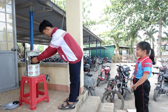 Học sinh sử dụng máy rửa tay tự động do em Lê Nguyễn Hoàng Triều sáng chế.