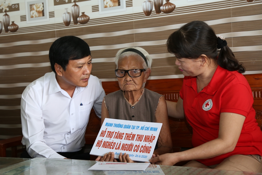 Đại diện Sở Lao động - Thương binh - Xã hội, Hội Chữ thập đỏ tỉnh trao bảng tượng trưng hỗ trợ thu nhập cho bà Đỗ Thị Hồng Châu - cựu tù chính trị.